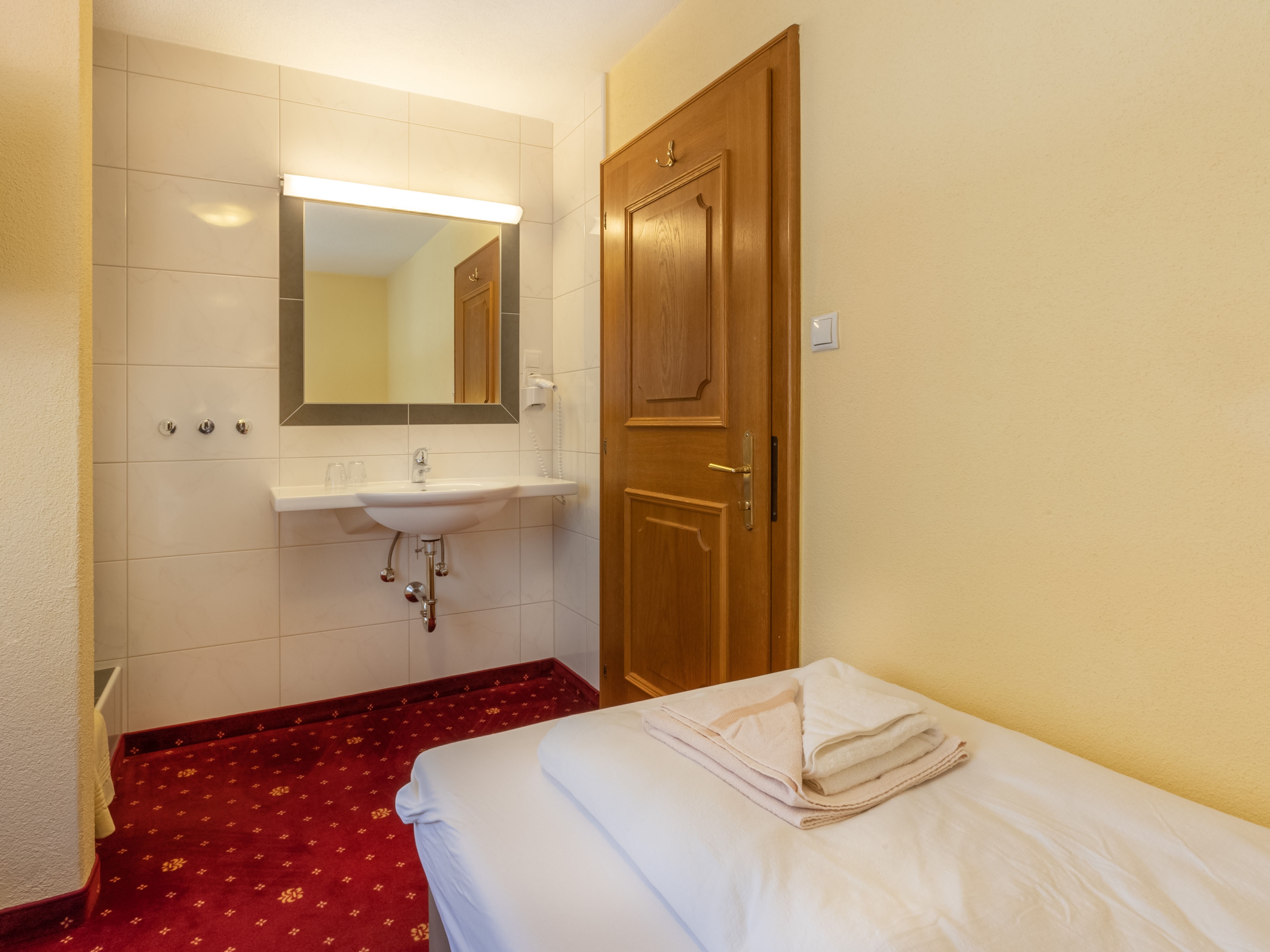 Regina's Apart: Apartment 5 - Waschbecken und Dusche im Zimmer mit zwei Einzelbetten